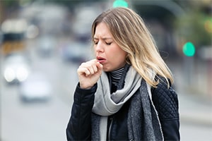 Young Woman Coughing in the Street